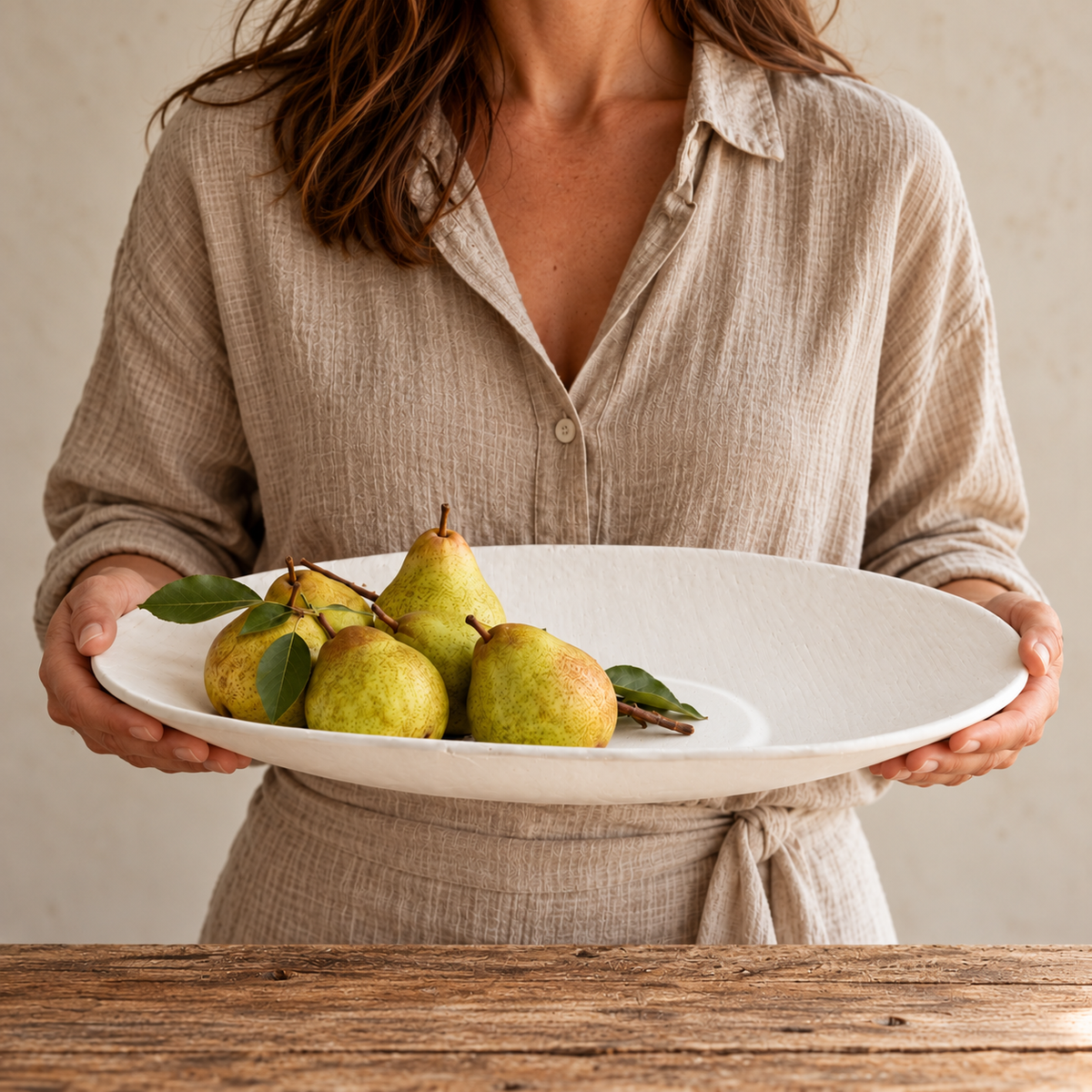 woman holding handmade linen serving bowls with pears