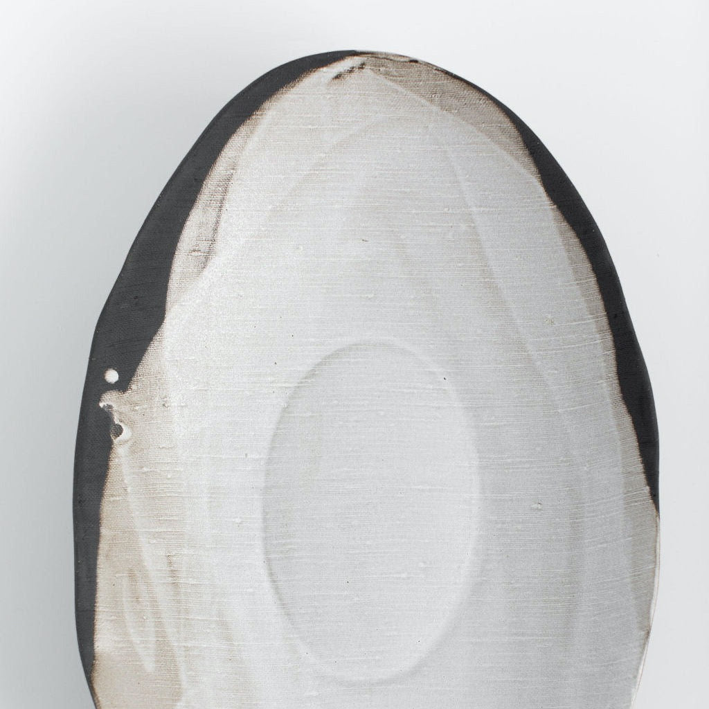 Overhead view of a Rustic Pour Over oval serving bowl with linen-textured White Matte glaze and exposed dark stoneware.