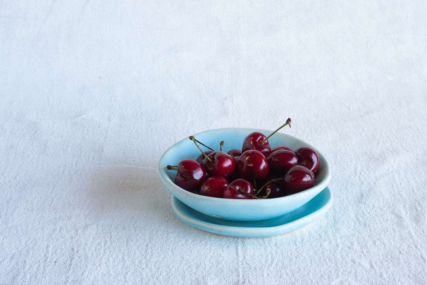 ceramic plate and collander with fresh cherries