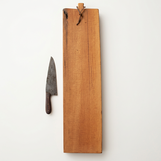 Number 126 Reclaimed Oak serving board with a leather hanging loop, styled beside a knife on a porcelain-white background.