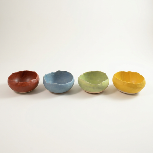 Four Vintage Colors handmade serving bowls in Rust, Dusk, Moss and Gold on a porcelain-white background.